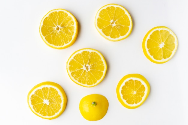 Lemon slices randomly lie on the light surface of the table.