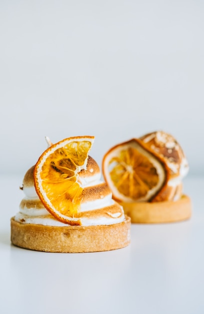 Lemon tartlet dessert with meringue on white background.