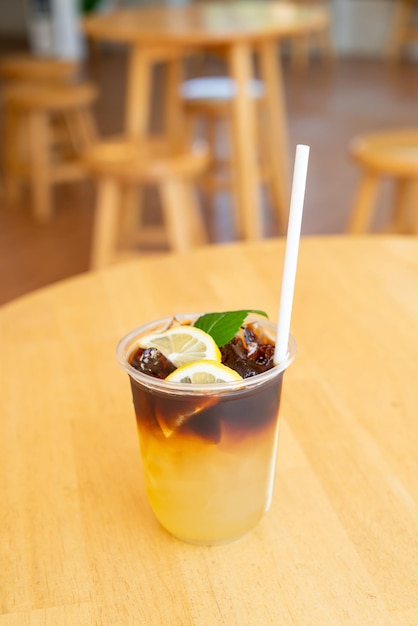 Lemon with black coffee in glass