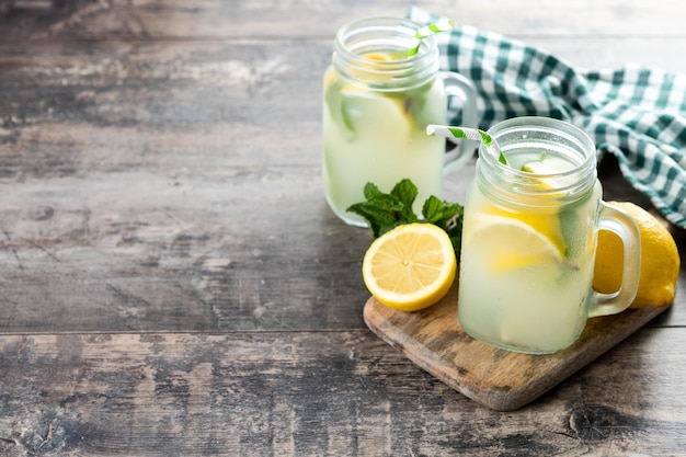 Lemonade drink in a jar glass and ingredients on wooden table