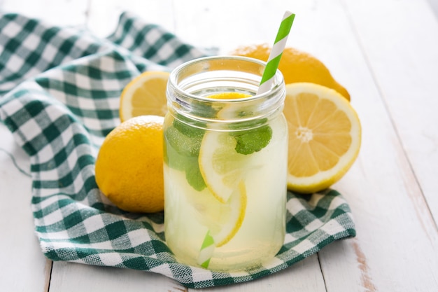 Lemonade drink in a jar glass on white wood table