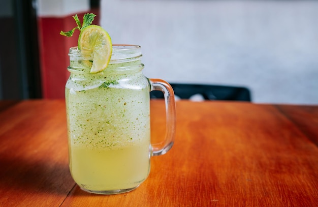 Lemonade drink on wooden background Refreshing lemonade with mint on wooden table