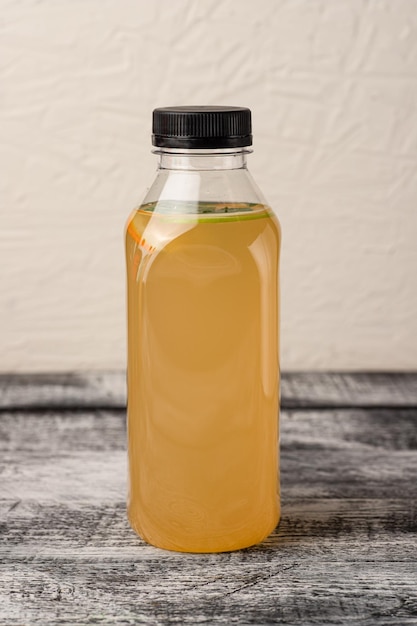 Lemonade homemade lemonade in a bottle on a white wooden background