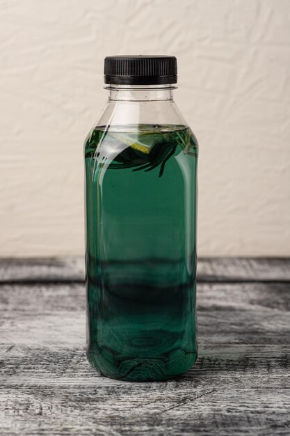 Lemonade homemade lemonade in a bottle on a white wooden background