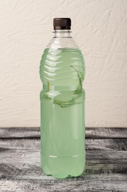 Lemonade homemade lemonade in a bottle on a white wooden background