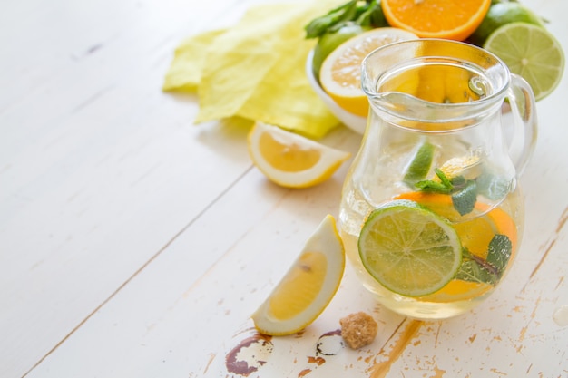 Lemonade and ingredients on white wood background