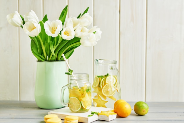 Lemonade, sweet macarons and tulip flowers