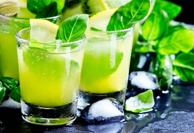 Lemonade with kiwi green basil grapefruit syrup and ice black background selective focus