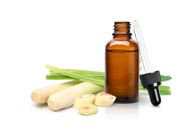 Lemongrass essential oil extract in amber dropper bottle with fresh lemongrass isolated on white background.