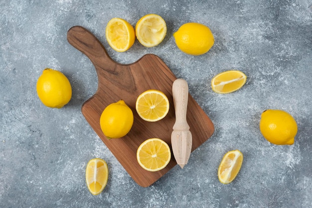 Lemons fresh and sliced on grey backround cutting board