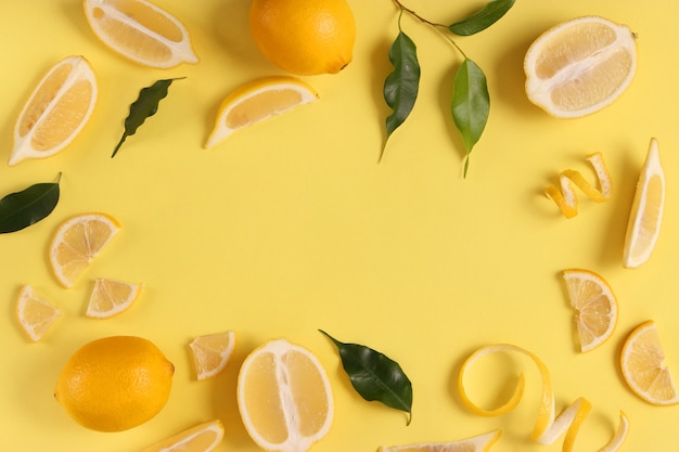 Lemons and green leaves on a colored background