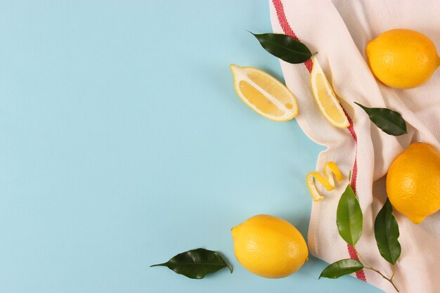 Lemons and green leaves on a colored background