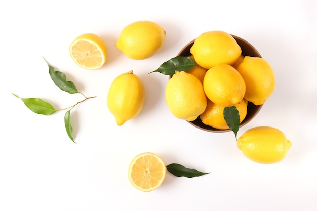 Lemons and green leaves on a colored background