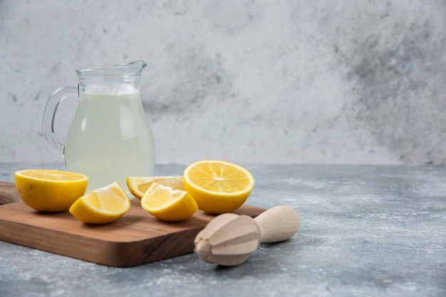 Lemons grey backround lemon juice and fresh on cutting board