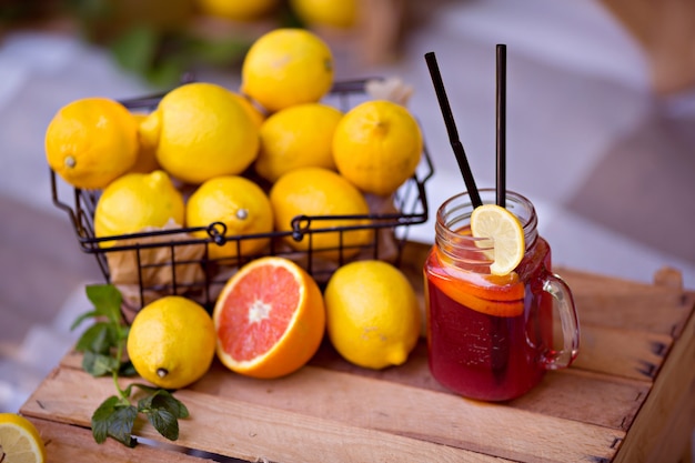 Lemons in a metal basket and a glass of lemonade