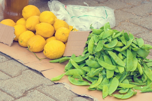 Lemons and peas on cardboard outdoors