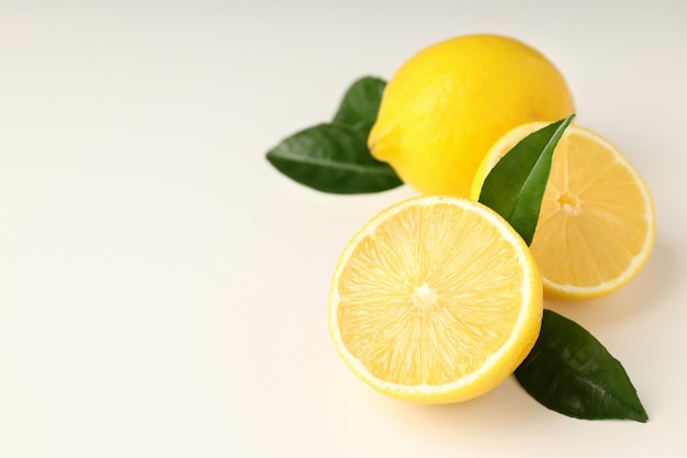 Lemons with leaves on white background, space for text