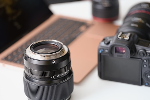 Lenses and camera lying on table near laptop closeup work as photographer concept