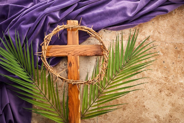 Lent season Holy week and Good friday concept Palm leave and cross on stone background