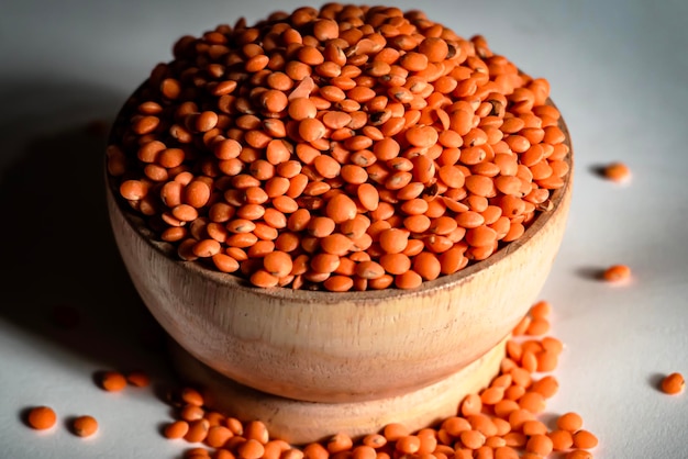 Lentil in a wooden bowl isolated on a white background Lentil is a common food of Asian people