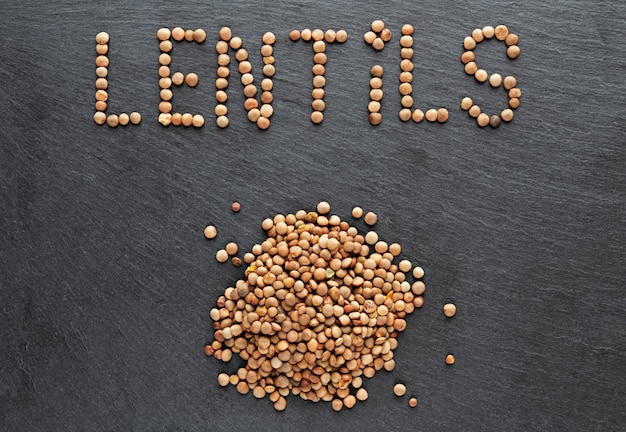 Lentils on dark stone background. Flat lay.