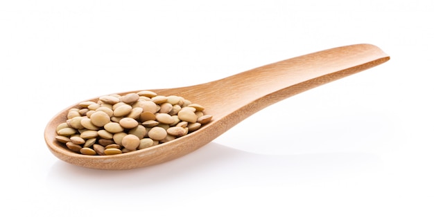 Lentils in wood spoon on white