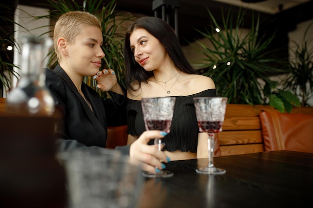 Lesbian couple on a date in a restaurant drinking wine