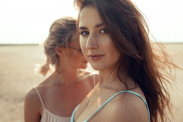 Lesbian couple have fun on beach Beautiful women friends happy relax near sea