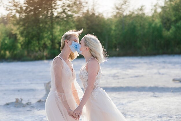 Lesbian couple wedding on white sand, wear masks to prevent epidemic COVID-19