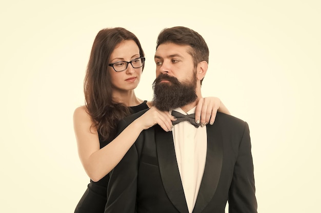 Let me help with bow tie Woman elegant lady adjust male bow tie Man bearded gentleman wear black tuxedo with bow tie Official dress code concept Couple getting ready visit formal event together