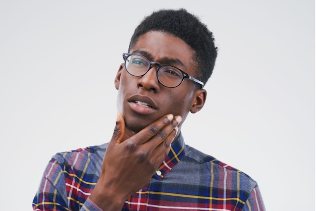 Let me take a look at my options Studio shot of a man looking thoughtful against a gray background