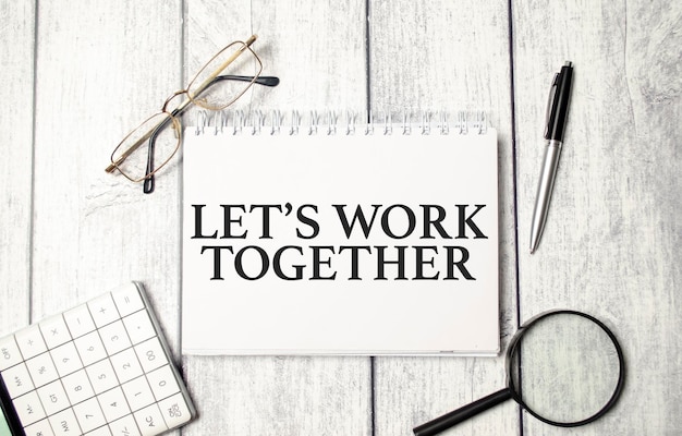 Let's work together words on notepad and pen calculator and glasses