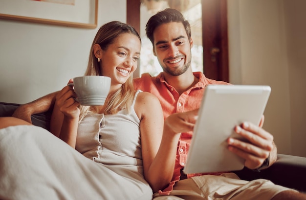 Lets look at that. Shot of a young couple using a digital tablet together at home.