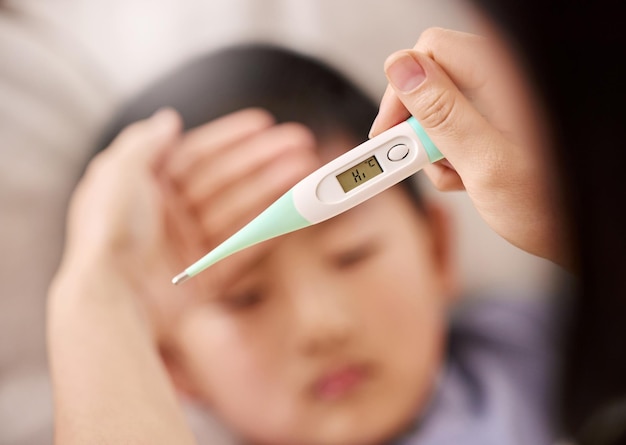 Lets see what we can do to bring your temperature down Cropped shot of a woman checking her sons temperature with a thermometer