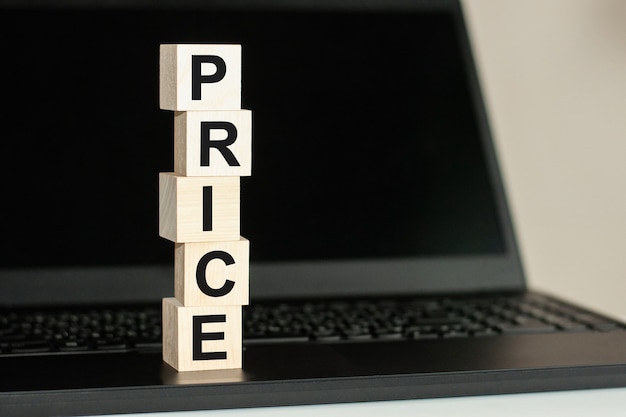 Letter block in word price on wood background, wooden block on computer keyboard against black background