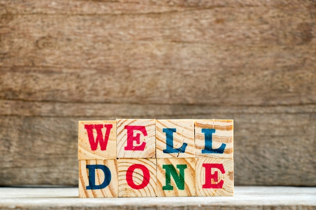 Letter block in word well done on wood background