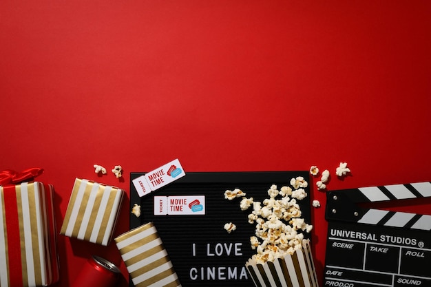 Letter board with text popcorn tickets and boxes on red background space for text