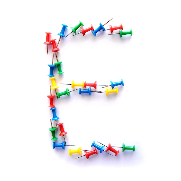 Letter E English alphabet from multicolored stationery office buttons, isolate on white background