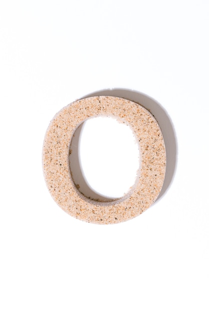 Letter O of the sand isolated in white summer concept alphabet