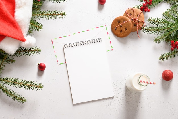 Letter for Santa Clause, homemade gingerbread cookies and milk on white.