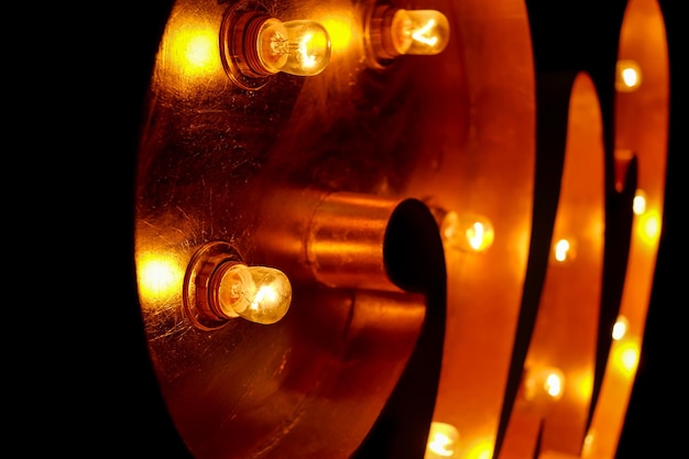 Photo letter for the sign with the bulbs letter w on a yellow light bulb and a black background