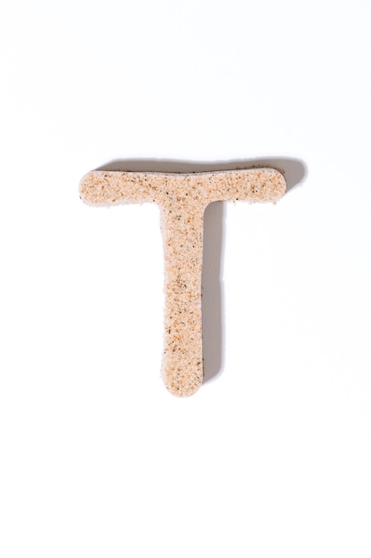 Letter T of the sand isolated in white summer concept alphabet