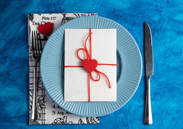 A letter with a heart on a blue plate