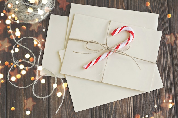 letters and christmas decor on brown wooden table with christmas lights.