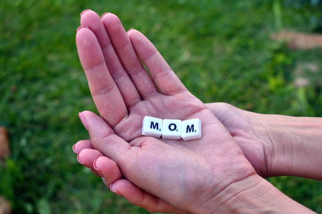 Letters mom laid out from game cubes. Word mom of letters and symbols.