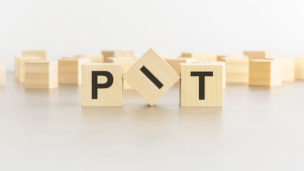 Letters PIT on wooden blocks white background