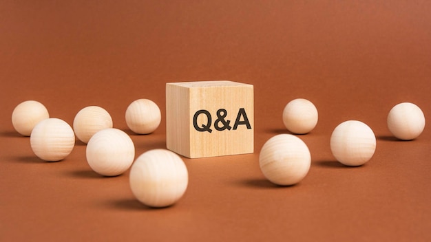 Letters 'Q and A' on wooden block wooden balls around concept