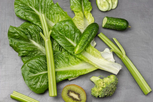 Lettuce cucumber and celery stalks on grey