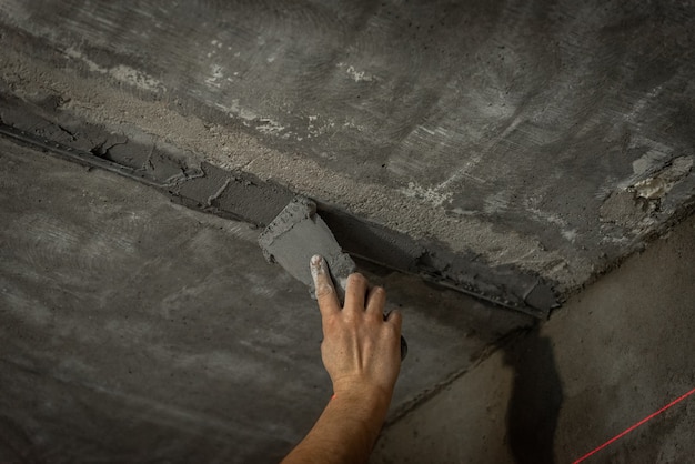 Leveling of the ceiling with plaster using beacons.