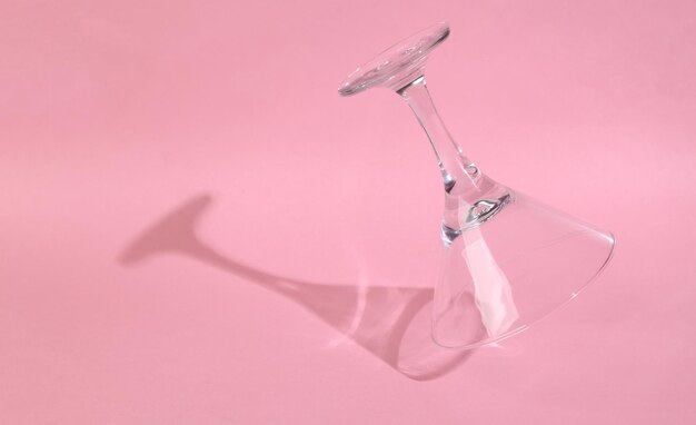 Levitating cocktail glass on pink background with long trendy shadow Minimal party layout